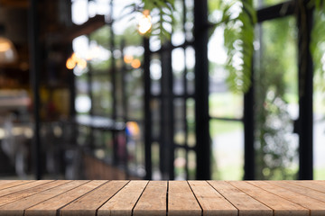 Wooden table in front blurred coffee shop background, abstract textured, used for presnetation and template