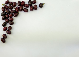 Fresh ripe cornelian cherry dogwood berry white paper with copy space.