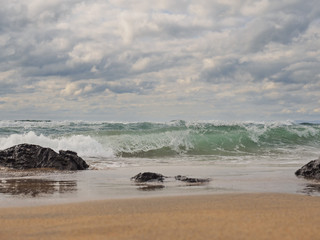 Ocean's wave splashing on the beach. cloudy day.