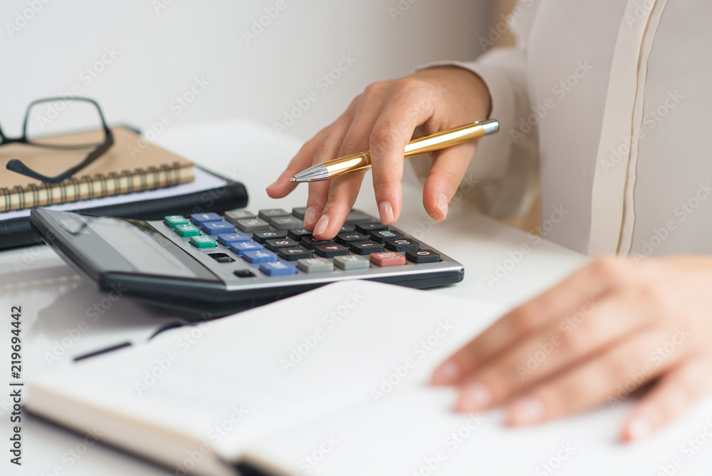 Wall mural closeup of accountant calculating profit. notebook, glasses and calculator lying on desk. accountanc