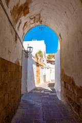 Beautiful Greek narrow street in historic Lindos on Rhodes island. Dodecanese, Greece.