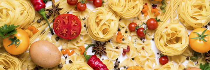 Italian pasta of different kinds with spices, red hot pepper, chicken eggs, yellow and red tomatoes...