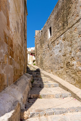 Historic narrow street with stone staircase in Lindos. Rhodes island, Greece