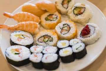 White plate full of sushi pieces