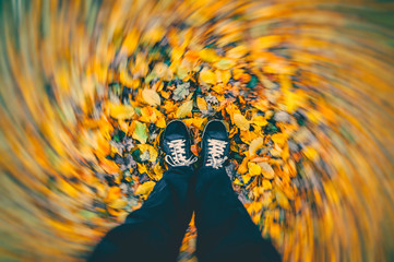 Strong wind blowing around man standing on dry autumn leaves