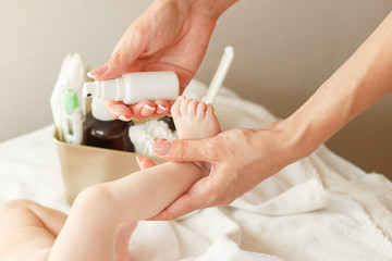 Hands of woman holds baby foot