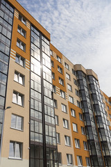 Modern apartment building in sunny day against blue sky.