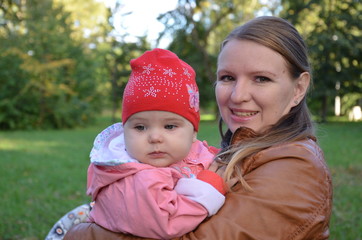 Young mother and her toddler girl having fun in autumn