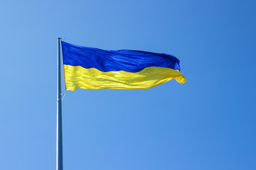 Ukrainian flag. Yellow-blue Ukrainian flag against the sky in the Dnipro. Ukraine's Independence Day. National symbol in the rays of the sun