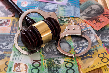 Judge's gavel with handcuffs on australian dollars
