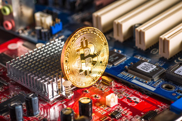 Golden Bitcoin Cryptocurrency on computer circuit board. Macro shot