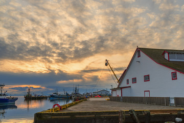 Fototapeta na wymiar Sunset on the ocean at the pier of fishing ships
