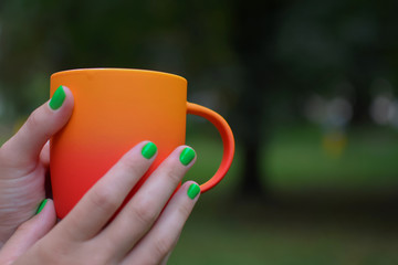 Чай в ярко-оранжевой кружке на свежем воздухе