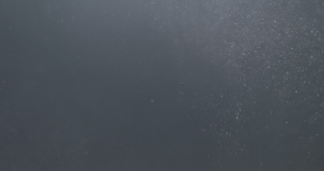 backlit dust particles explosion effect on a black background with motion blur