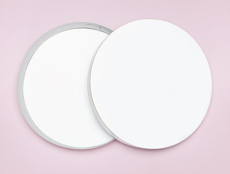 Round white cardboard blank box top view flat lay. Mock up on pink background. Packaging design, an empty box for shopping.