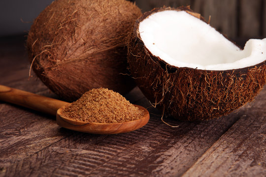 scoop of brown sugar with coconut on wooden background