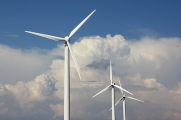 Modern power wind farm in summer against blue sky with white clouds
