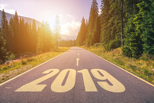 Empty asphalt road and New year 2019 concept. Driving on an empty road in the mountains to upcoming 2019 and leaving behind old 2018. Concept for success and passing time.