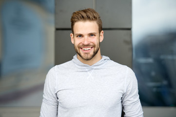 Sincere smile concept. Man with perfect brilliant smile unshaven face urban background. Guy happy emotional expression outdoors. Bearded and handsome. Man happy cheerful face white brilliant teeth
