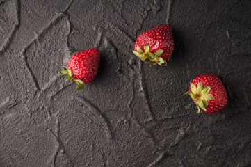 Fresh strawberries in a plate on a black background.