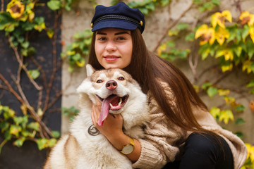 Cute dog and woman faces close-up portrait. Vertical outdoor shot