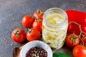 Marinated spicy  feta in a jar and vegetables for salad.