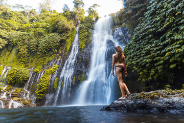 Young sexy woman looking at the waterfall Banyumala in jungles. Ecotourism concept image travel girl. Bali, Indonesia