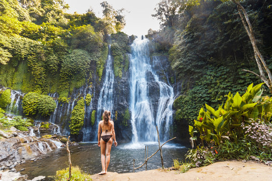 Young sexy woman looking at the waterfall Banyumala in jungles. Ecotourism concept image travel girl. Bali, Indonesia