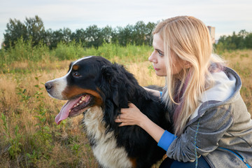 portrait of a big dog and a girl in nature. the hostess with the pet look aside