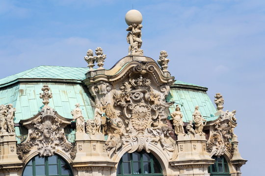 Atlas god statue holding sphere on shoulders, Wallpavillon Zwinger palace, Dresden, Germany, sunny day clear blue sky background