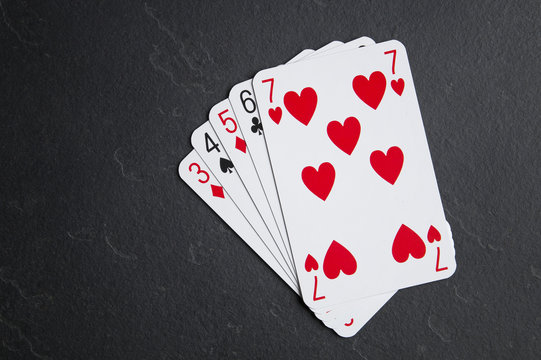 Poker cards on a dark background. Strit five cards in succession.
