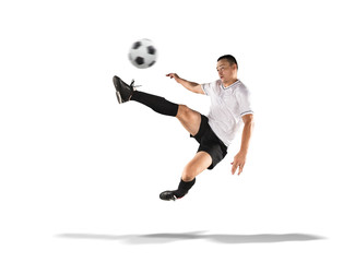 soccer player kicking the ball in the air isolated on white