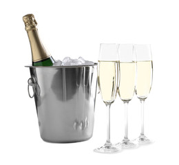 Glasses with champagne and bottle in bucket on white background