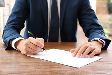 Lawyer working with documents at table, focus on hands