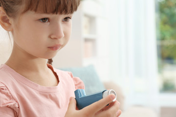 Little girl with asthma inhaler on blurred background - obrazy, fototapety, plakaty