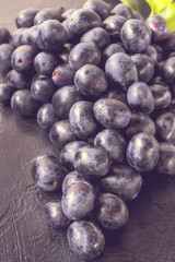 Fresh ripe Bunches of black Grapes berries on kitchen table