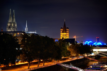 Fototapeta premium View of Cologne Dom Cathedral and Great St Martin Church at night from the chocolate museum