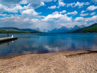Two tourist take time to observe the Howe Ridge fire kicking up from the comfort of Apgar Village dock.