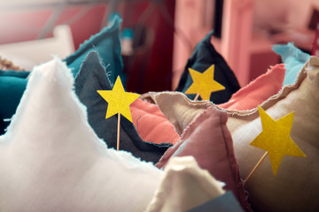 Star shaped pillows in the bedroom. Yellow decorative stars on the wand stick