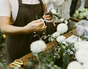 Woman is crafting the wreath of flowers. Beautiful nature floral head crown
