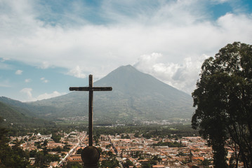 Catholic cross at the top of the Cerro de la Cruz looking over the city of Antigua, Guatemala and volcano Acatenango