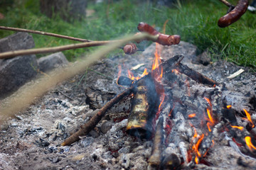 sausages on stick over the bonfire and baked potato
