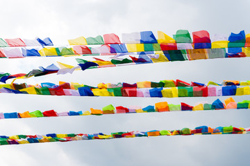 Traditional buddhist prayer flags over blue sky background