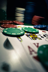 Poker Chips and playing cards on a green felt poker table