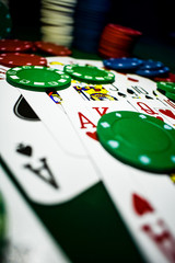 Poker Chips and playing cards on a green felt poker table