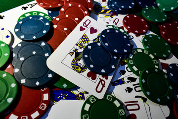 Poker Chips and playing cards on a green felt poker table