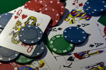 Poker Chips and playing cards on a green felt poker table