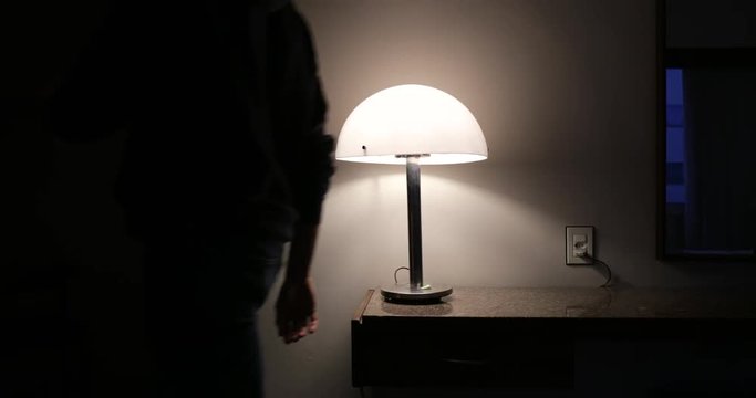 Person leaving apartment turns off lamp