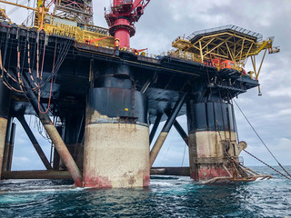 Semi submersible drilling rig view from crew vessel's deck. Rig deballasted so legs can be seen at...