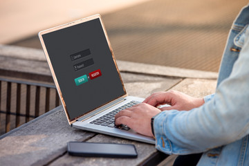 A man is working using laptop doing sign in membership username password on screen at outdoor